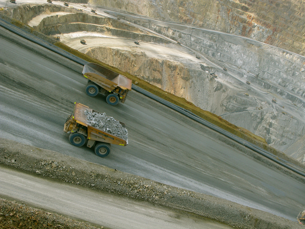 An exploration field at Batu Hijau, West Nusa Tenggara, operated by PT Newmont. (Randi Ang) Two carts rest on a mining site path. The photo is taken at an angle where the path appears to be going down from left to right.