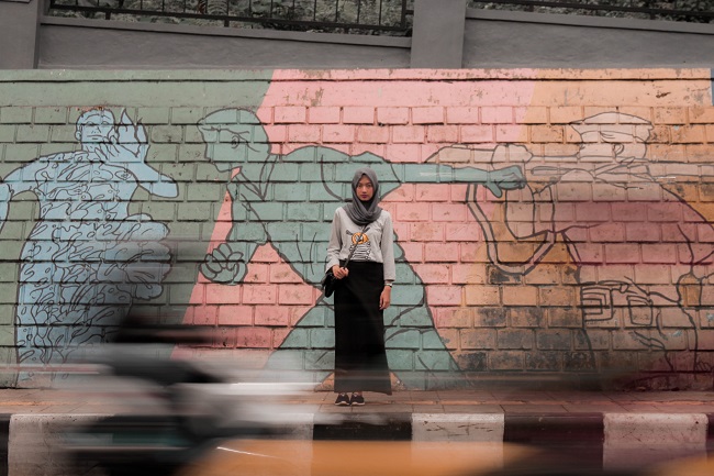 A woman gazes at the camera as the world moves around her / Ghiffar Ridhwan on Unsplash