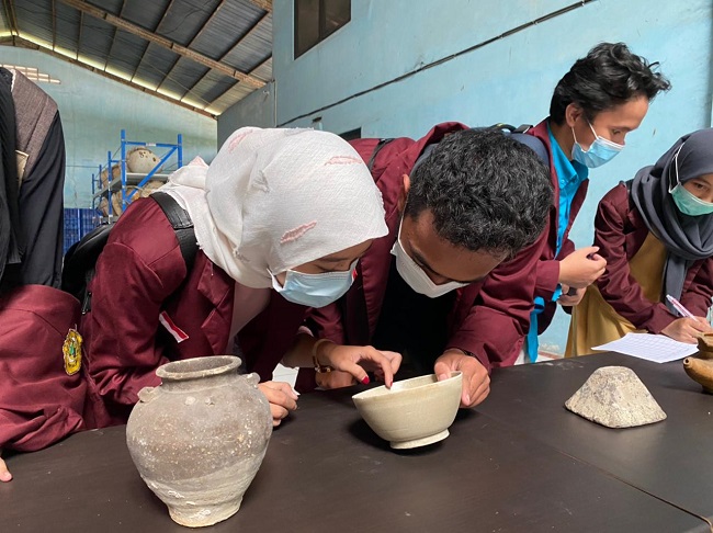 Students inspecting shipwreck artefacts at a Ministry of Marine Affairs and Fisheries warehouse in Cileungsi  / Zainab Tahir